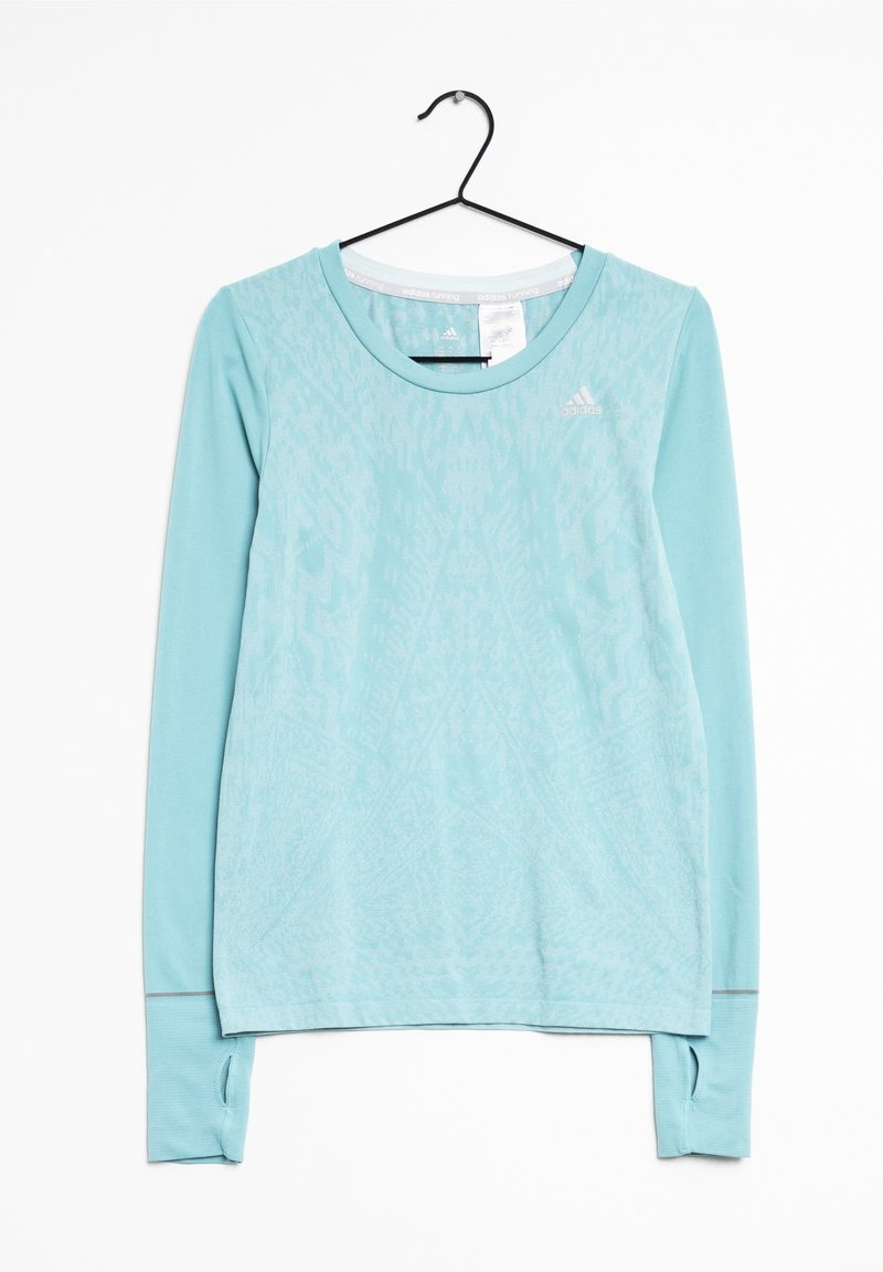 Chemise de sport Adidas bleu clair à manches longues avec un motif subtil, trous pour les pouces sur les poignets, suspendue sur un cintre noir contre un fond blanc.