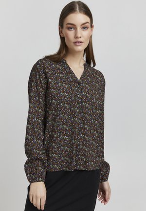 Svart bluse med blomsterprint i flere farger. Har V-hals og lange pufferm med tettsittende mansjetter. Lett stoff.