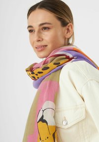 Écharpe multicolore avec un motif d'animaux, en tissu doux ; nuances de rose, jaune et orange avec des designs abstraits.