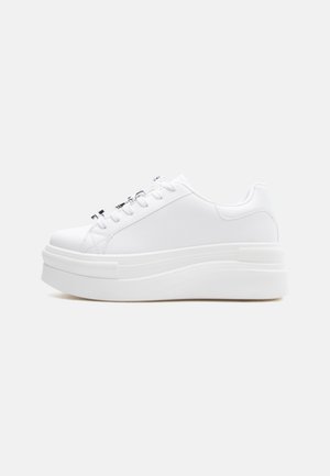 Λευκό αθλητικό παπούτσι με πλατφόρμα και χοντρή σόλα, με κορδόνια στο μπροστινό μέρος και λείο επάνω μέρος, εμφανιζόμενο από την εσωτερική πλευρά σε απλό φόντο.