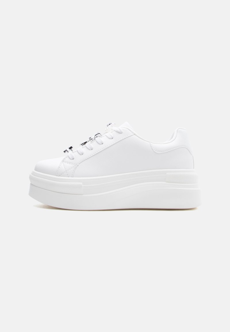 Λευκό αθλητικό παπούτσι με πλατφόρμα και χοντρή σόλα, με κορδόνια στο μπροστινό μέρος και λείο επάνω μέρος, εμφανιζόμενο από την εσωτερική πλευρά σε απλό φόντο.
