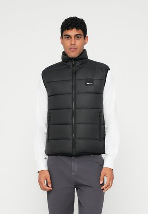 Zwarte puffer vest met hoge kraag, ritssluiting aan de voorkant en zijzakken. Gladde textuur, doorgestikt ontwerp met rechthoekige segmenten, logo op de borst.