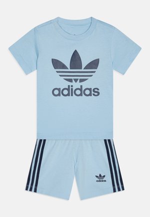 Light blue Adidas two-piece set featuring a t-shirt with a dark blue logo and matching shorts with navy side stripes and logo accents.