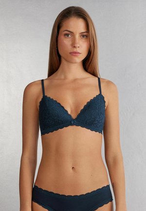 Soutien-gorge triangle en dentelle bleu foncé avec des bords festonnés et des bretelles réglables. Présente des motifs floraux et un petit détail décoratif au centre.