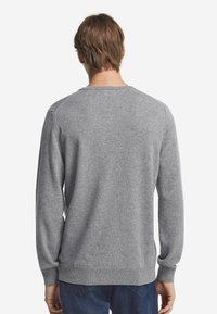 Grauer Strickpullover mit Rundhalsausschnitt, gerippten Bündchen und Saum. Weicher Stoff, einfaches Design ohne sichtbare Muster oder Akzente.