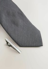 Gray herringbone tie with a silver tie clip. The tie features a textured pattern, while the clip has a polished metallic finish.