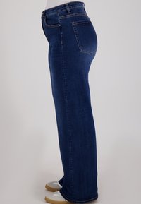 Blauwe spijkerbroek met een rechte pasvorm, voorzien van een middelhoge taille, achterzakken en een gladde textuur.