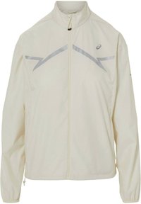 Lichtbeige ritsjack met hoge kraag, lange mouwen, elastische manchetten en reflecterende zigzagstrepen over de borst en schouders.