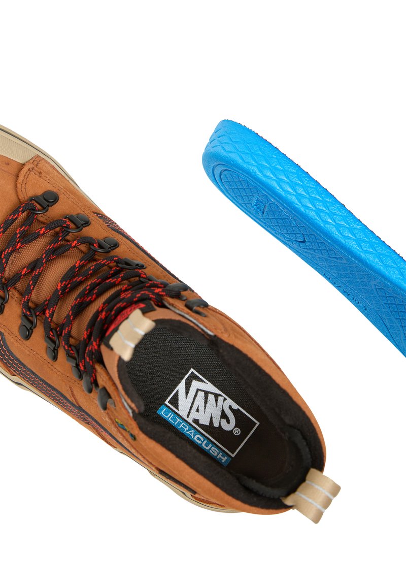 Sneaker alta in suede marrone con lacci neri e rossi, dotata di una soletta ULTRACUSH nera e blu e una suola blu testurizzata.