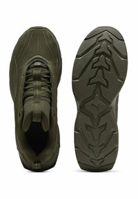 Scarpe sportive verde oliva con tomaia in rete testurizzata, tallone rinforzato e suola in gomma stampata con un design di grip multidirezionale.