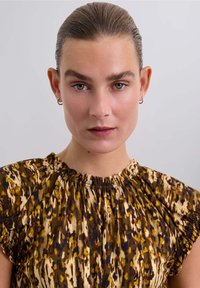 Vestido estampado en marrón y beige con escote fruncido y mangas cortas, que presenta una tela suave y liviana y una silueta relajada.
