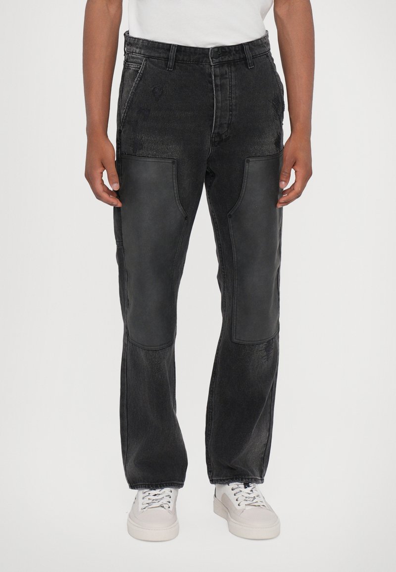 Pantalons en denim noir avec des panneaux en cuir à l'avant, coupe décontractée, design à jambe droite et détails cousus. Associés à des baskets blanches.