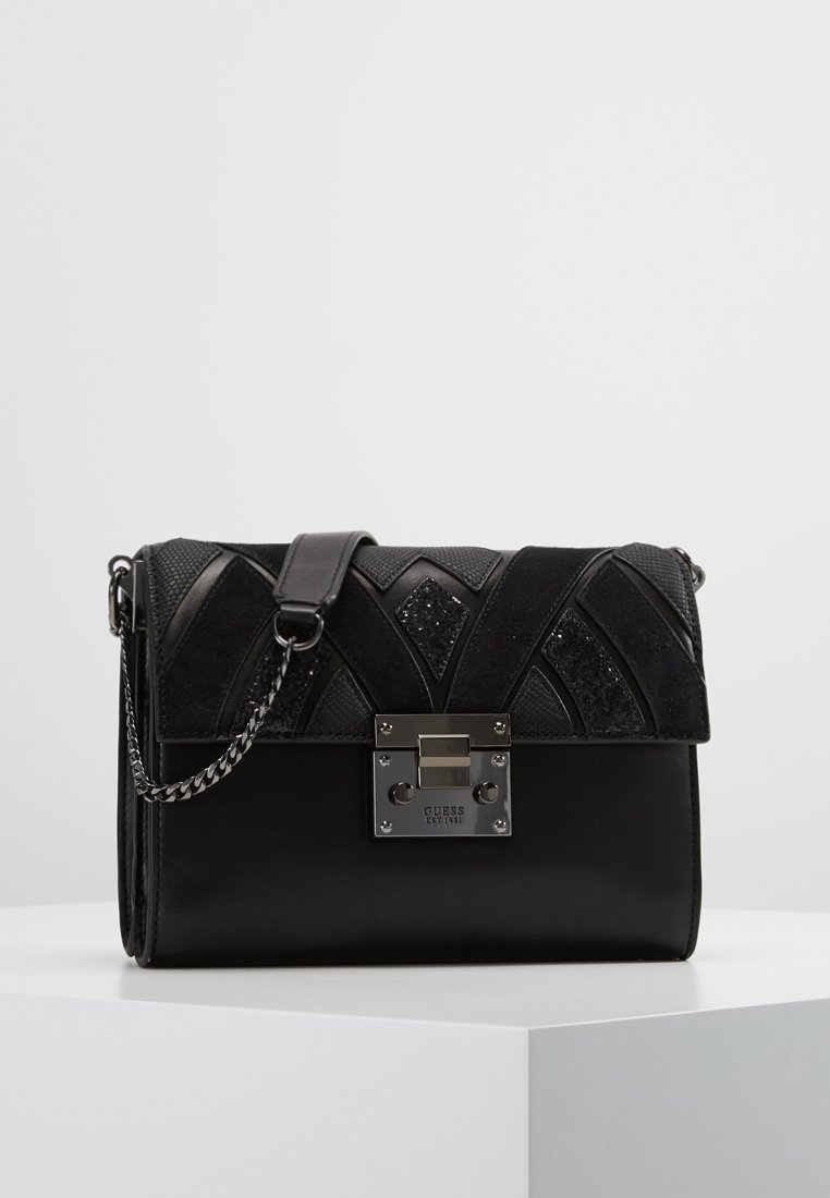 Czarna torebka z geometrycznymi wzorami zamszu i tkaniny o fakturze, metalowym zamkiem oraz paskiem na łańcuszku. Gładkie wykończenie z błyszczącymi akcentami.