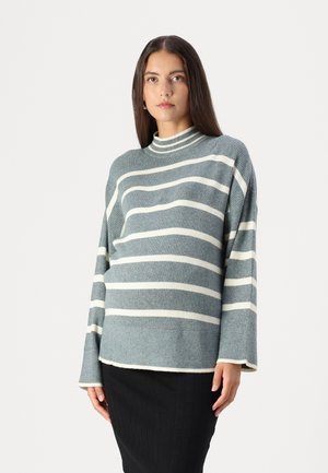 Gray striped sweater with a high collar, featuring horizontal white stripes, long sleeves, and ribbed texture, paired with a black ribbed skirt.