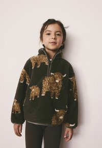 Fleece pullover in dark green, featuring brown Highland cattle patterns and a zip neck. Soft, fluffy texture with a relaxed fit.