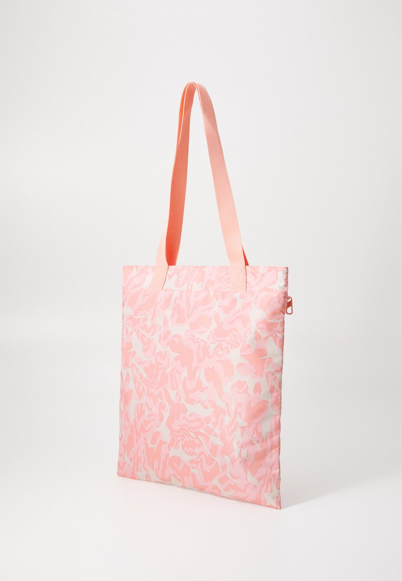 Roze draagtas met een zachte textuur, versierd met een wit abstract patroon, voorzien van bijpassende roze hengsels en een ritsluiting aan de zijkant.