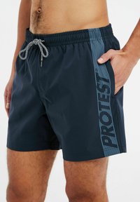 Navyblauwe badshorts met een elastische tailleband en een verstelbaar trekkoord, voorzien van een lichtblauwe logo aan de zijkant en een soepele textuur.
