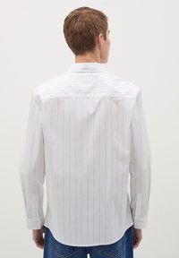Witte overhemd met lange mouwen met dunne verticale strepen, met knoopmanchetten en een achter yoke. De stof heeft een gladde textuur en een subtiele glans.