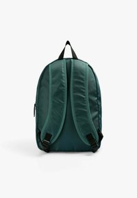 Mochila verde de nailon con correas ajustables y acolchadas, un asa superior y un compartimento principal con cremallera. Acabado suave y mate con una forma aerodinámica.