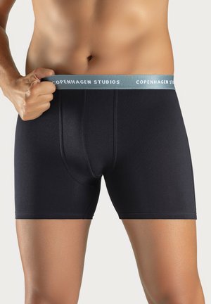 Black boxer briefs with a smooth texture, featuring a light blue waistband with "COPENHAGEN STUDIOS" printed in white.