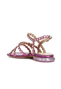 Sandali rosa con tacco a blocco trasparente, abbelliti con accenti circolari in oro e strass trasparenti, caratterizzati da delicate cinghie incrociate.