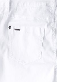 Witte denim stof met een enkele achterzak met een gestikte rand en een klein, metallic logo accent. Gladde textuur en een strakke uitstraling.