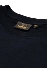T-shirt in cotone blu navy con collo rotondo. Presenta un'etichetta con il marchio "Switcher" e informazioni sulla taglia. Texture liscia.