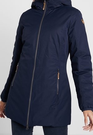 Marineblaue lange Kapuzenjacke mit Frontreißverschluss, Reißverschlusstaschen, elastischen Bündchen, getragen von einer Person vor einfarbigem Hintergrund.