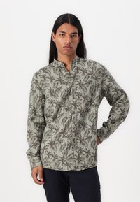 Grøn knap-fra skjorte med et palmeblad mønster, lange ærmer, mandarin krave og en afslappet pasform. Stoffet virker letvægts og struktureret.