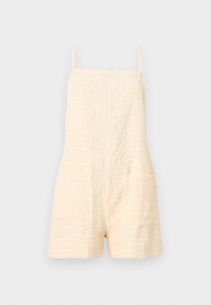 Ολόσωμο σορτς από κρεμ υφασμάτινη ύφανση με λεπτές τιράντες και δύο μπροστινές τσέπες, σχεδιασμένο για καθημερινή χρήση.