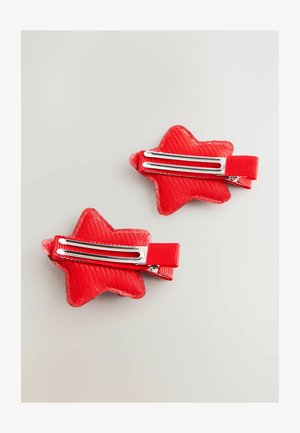 Red star-shaped hair clips made of textured fabric with metal clips, featuring a ribbed ribbon accent and a glossy finish. Two pieces shown.