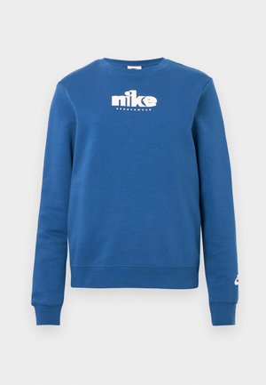 Sudadera azul de algodón con mangas largas, cuello redondo y logo blanco de Nike en el pecho. Los puños y el dobladillo acanalados mejoran el ajuste.