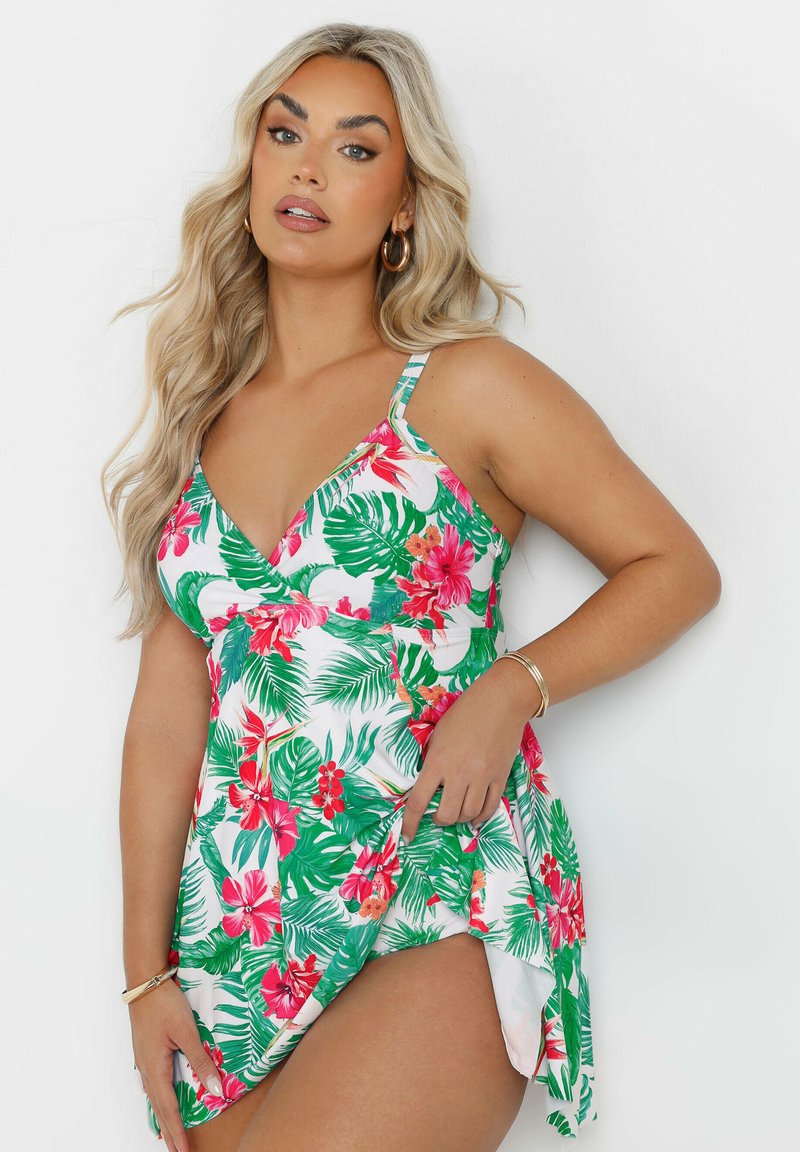 Costume da bagno con stampa floreale bianca, caratterizzata da vivaci foglie verdi e fiori rosa. Ha spalline sottili e una gonna fluida e a strati.