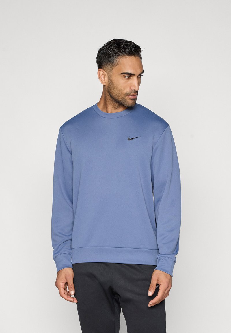 Sweatshirt à manches longues Nike en tissu bleu doux avec un col rond, des poignets côtelés et un petit logo noir sur la poitrine gauche.