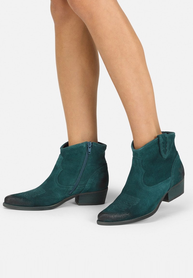 Türkise Wildlederankelstiefel mit seitlichem Reißverschluss, spitzem Schuhschaft, niedrigem Blockabsatz und dekorativer Steppnaht entlang des Schafts und der Zehen.