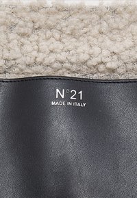 Black leather product with a textured beige woolen upper. Features embossed brand "N°21" and "MADE IN ITALY" in silver lettering.