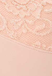 Peach-colored fabric with a textured lace overlay featuring intricate patterns. Smooth, stretchable bottom layer complements the lace.
