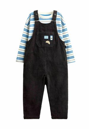 Børneoutfit med sorte corduroy-havetrusser med snack-tema patches og en langærmet hvid skjorte med blå striber under.