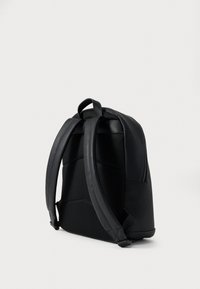Fekete hátizsák texturált hálós háttámlával, sima oldalakkal és párnázott pántokkal. Elegáns kialakítás finom varrási részletekkel.