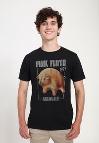 Černé tričko s velkým ilustrovaným grafikou prasete v jemných hnědých tónech, doplněné textem "PINK FLOYD 1977 ANIMALS."