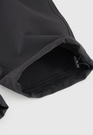 Zwarte stoffen mouw met elastische manchet, met een gladde textuur en subtiele glans. Verstelbaar trekkoord bij de opening voor een goede pasvorm.