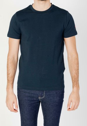 Camiseta de algodón de manga corta en color azul marino. Cuello redondeado con un sutil detalle de logo en la manga izquierda. Textura suave, diseño ajustado.