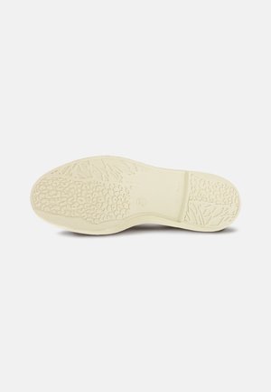 Semelle de chaussure en caoutchouc de couleur blanc cassé avec des motifs texturés, présentant un design antidérapant et un bord lisse. Matériau durable et flexible.