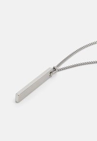 Collar de metal en tono plateado que presenta un colgante rectangular con bordes suaves, unido a una delicada cadena con una textura retorcida.