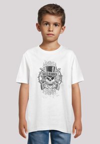 Weißes Baumwoll-T-Shirt mit einem grafischen Druck eines Schädels, Zylinders und gekreuzten Waffen in Schwarz- und Grautönen auf einem einfarbigen Hintergrund.