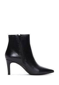 Botas de cuero negro hasta el tobillo con punta afilada y cremallera lateral, que presentan un tacón alto y delgado, además de una textura suave.