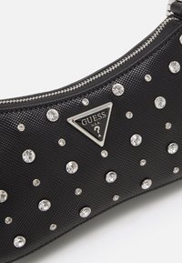 Czarna torebka kopertówka z teksturowanej skóry ozdobiona przezroczystymi cyrkoniami, z trójkątną srebrną naszywką logo oraz srebrnym zapięciem na zamek.