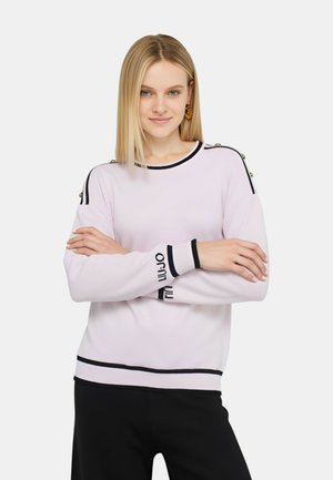 Maglione rosa chiaro con strisce nere e testo sulle maniche, con dettagli in bottone dorato sulle spalle e un collo e un orlo a coste.