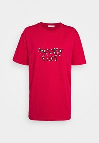 Rød bomulds T-shirt med en iøjnefaldende, udskåret "SeeBy Girl" grafik med blomster mønstre. Rund hals og korte ærmer.
