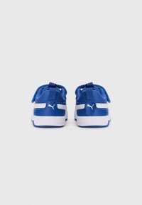 Une paire de baskets Puma bleues et blanches pour enfants montrées de dos sur un fond blanc uni.